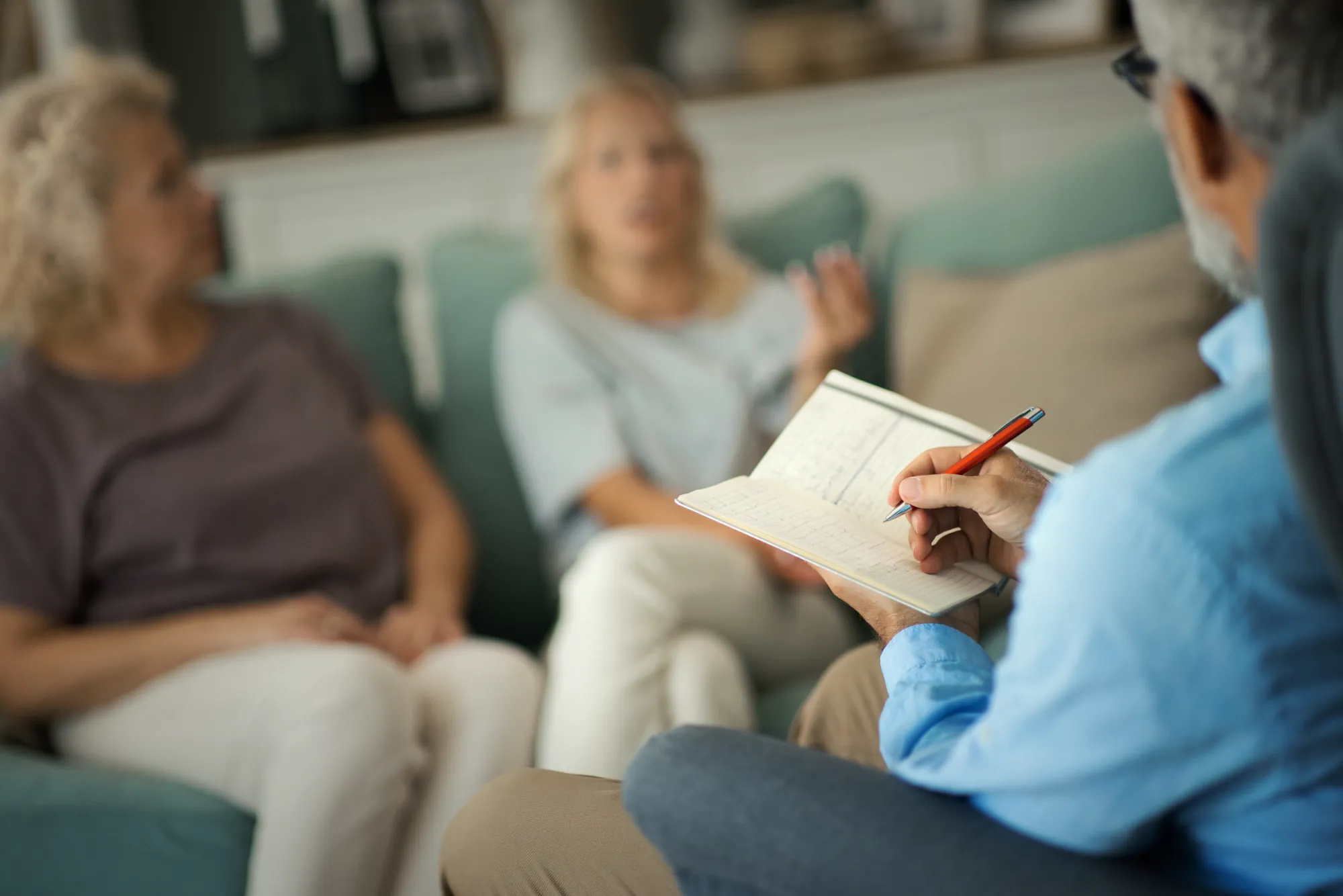 Two people sitting on a couch with a therapist.